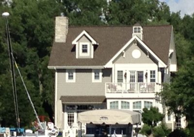 a long distance photo of a three floored cream and brown boat house