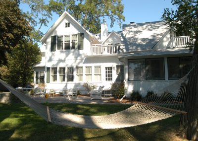 rear shot of white, two story Borland house at golden hour with a hammock and back patio furniture.
