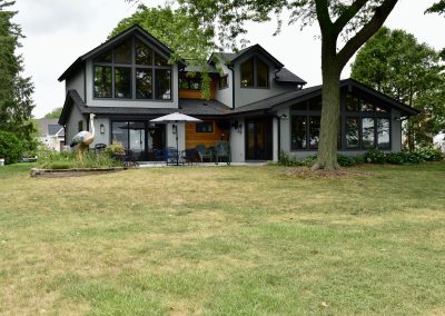 a gray and wooden modern house with large windows