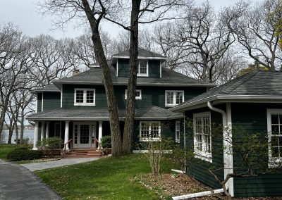 exterior shot of green three floor lake house